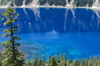 USA, Oregon, Cliffs reflected in calm surface of Crater lake