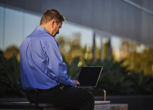 Man working on laptop outdoors