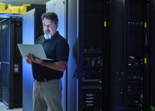 Man using laptop in data center