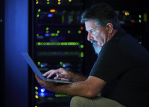 Man using laptop in data center