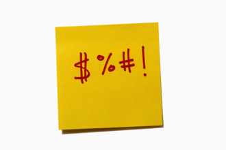 Studio shot of expletive icons on yellow post it note