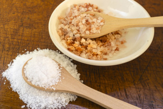 White and pink salt crystals on wooden spoons
