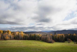 USA, New York, Saranac Lake, Clouds over fields and trees in Autumn