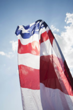 Low angle view of American flag against sky