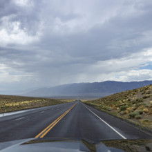 USA, Nevada, Winnemucca, Empty road and storm clouds seen from car