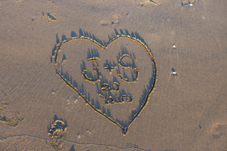 Heart with message in sand
