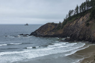USA, Oregon, Sea waves washing beach and headland near Cannon Beach