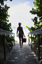 USA, United States Virgin Islands, St. John, Woman on path to tropical beach