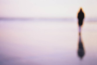 USA, New Jersey, Spring Lake, Defocussed image of woman and reflection on wet beach sand