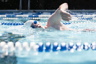Man swimming laps in outdoor pool