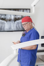 Dentist looking at smartphone after analyzing X-ray