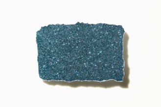 Torn blue glitter paper on white background