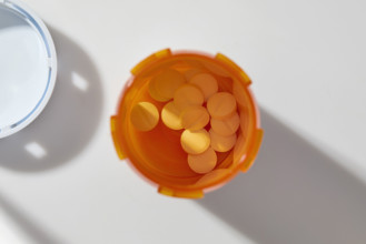 Overhead view of pills in open bottle