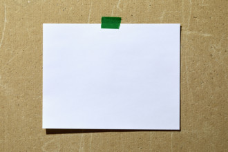 Blank paper taped to rough textured wall