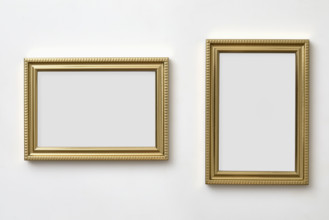 Gold decorative picture frames on white wall