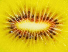Halved kiwi showing yellow inside and seeds