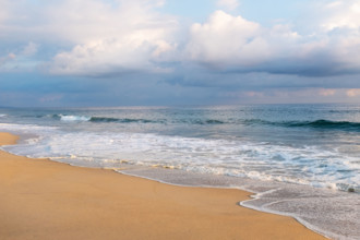 Mexico, Oaxaca State, Puerto Escondido, Costa Chica, Clouds over ocean waves on empty beach