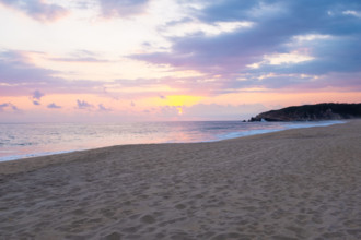Mexico, Oaxaca State, Puerto Escondido, Costa Chica, Sun setting over ocean and empty beach