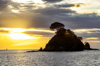 Costa Rica, Guanacaste, Playa Flamingo, Silhouette of small island at sunset
