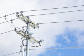 Utility pole with icicles against sky