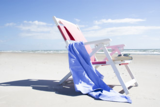 Empty chair with blue blanket on beach