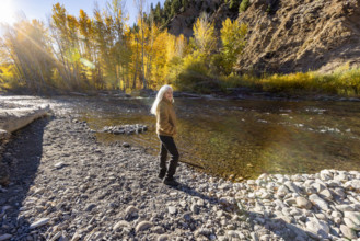 USA, Idaho, Hailey, Portrait of senior blonde woman at river in autumn