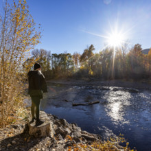 USA, Idaho, Bellevue, Woman facing Big Wood River on sunny autumn day