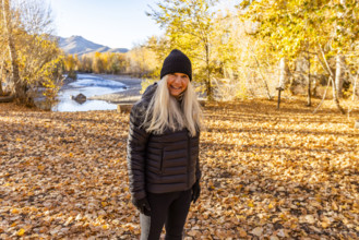USA, Idaho, Bellevue, Portrait of smiling woman near Big Wood River in autumn