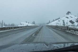 USA, California, Donner Pass, Empty highway seen from car during rain in winter