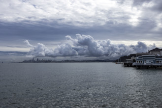 USA, California, Sausalito, Puffy clouds above city skyline across bay