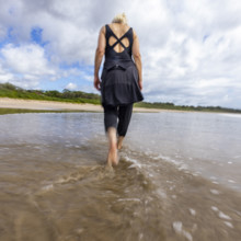Costa Rica, Guanacaste, Playa Grande, Rear view of woman walking on empty beach