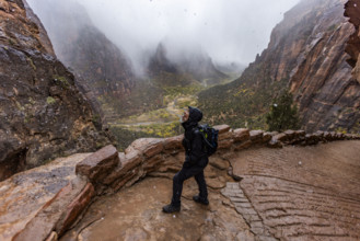 USA, Utah, Zion National Park, Female hiker catching snowflakes on tongue on trail to Angels