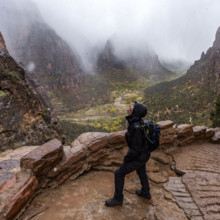 USA, Utah, Zion National Park, Female hiker catching snowflakes on tongue on trail to Angels