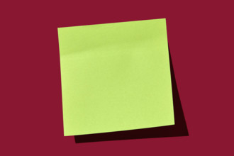 Blank green post it note on red background