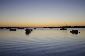 USA, Massachusetts, Nantucket, Boats on calm Polpis Harbor at sunset