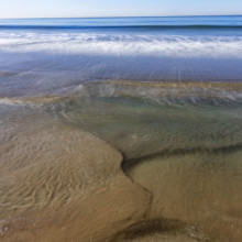 USA, California, Santa Monica, Motion blurred ocean waves on empty Santa Monica Beach