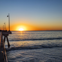 USA, California, Venice, Sun setting above calm ocean and Venice Pier