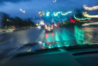 Traffic on road in rain at dusk seen from carmotion blur