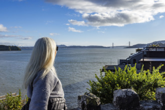 USA, California, Tiburon, Senior woman viewing Golden Gate Bridge in distance across San Francisco