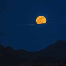 Pink Moon rising over cloud bank. Bellevue, Idaho, USA.