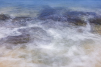 Close-up of motion blurred ocean water on sand. Kona, Hawaii, USA.