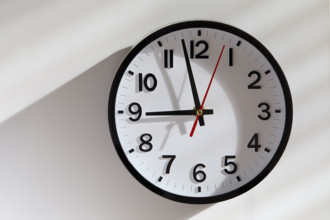 Wall clock with sunlight and shadow Background. New York City, New York State, USA.