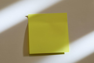 Blank yellow post it note on wall. New York City, New York State, USA.
