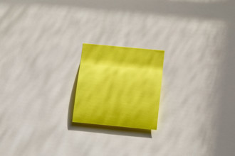 Blank yellow post it note on wall. New York City, New York State, USA.