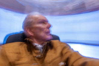 Senior man in desk chair, motion blurred. Bellevue, Idaho, USA.