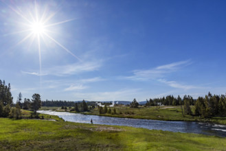 Sun on blue sky over Firehole River . , Wyoming, USA.