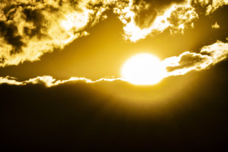 Golden sun setting behind clouds. Bellevue, Idaho, USA.