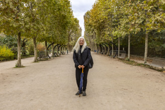 Portrait of smiling woman in Jardin des Plantes. Paris, Ile de France, France.