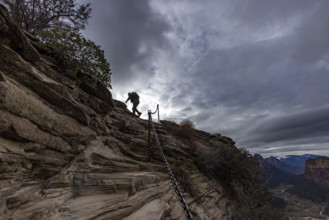 Low angle view of female hiker climbing top of Angels Landing. , Utah, USA.
