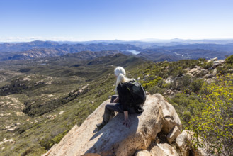 Senior blond hiker looking at view from top of Iron Mountain. Temecula, California, USA.